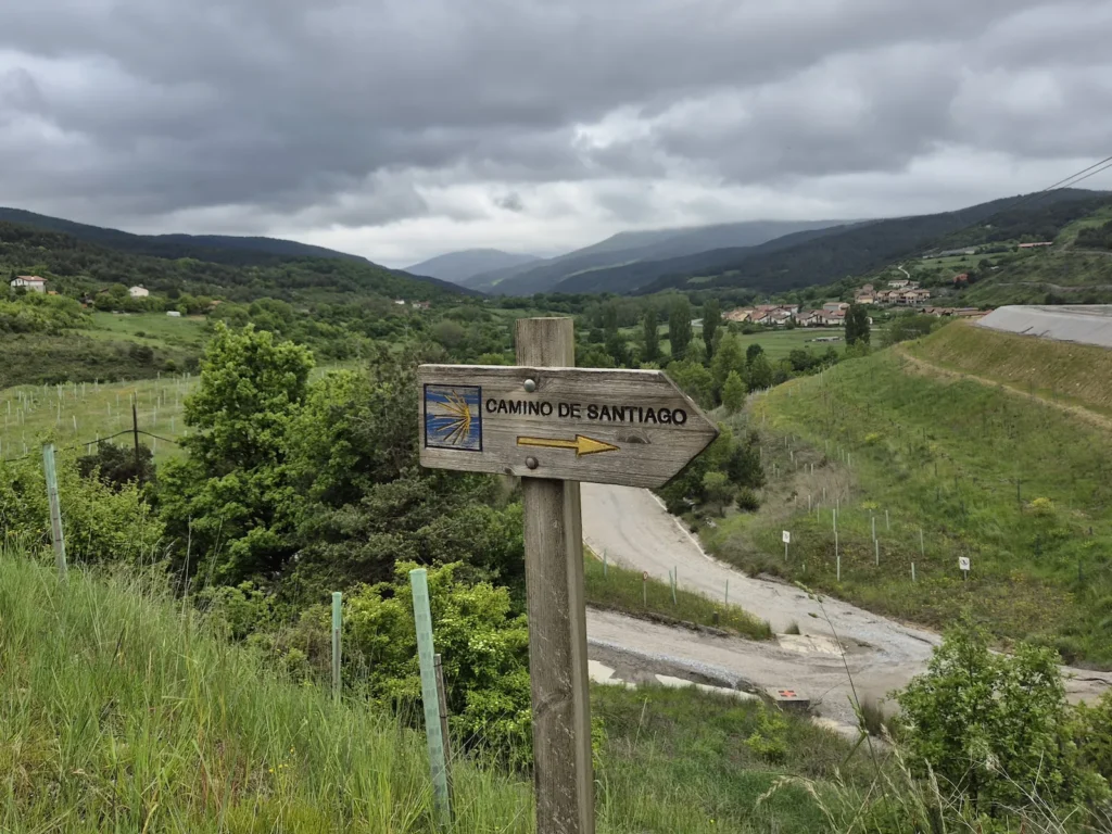 Camino de Santiago sign in front of a green, hilly landscape in Navarra