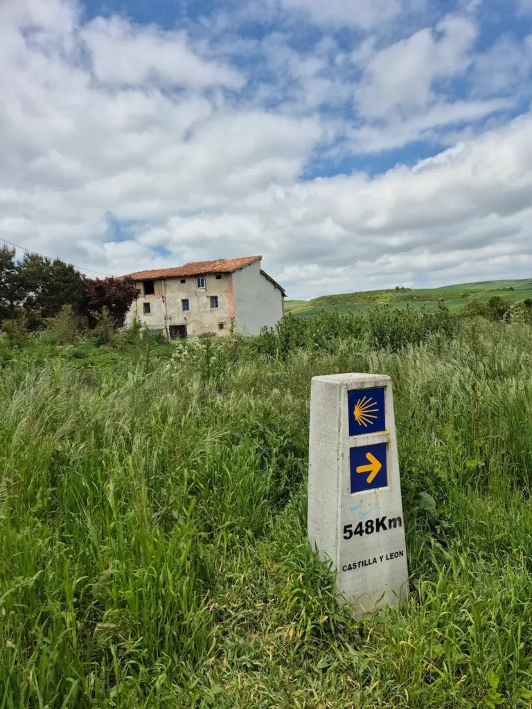 Distance marker in a wheatfield on the Camino de Santiago