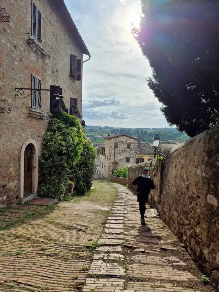 Simon walking down a cobblestone street in Colle di Val d'Elsa