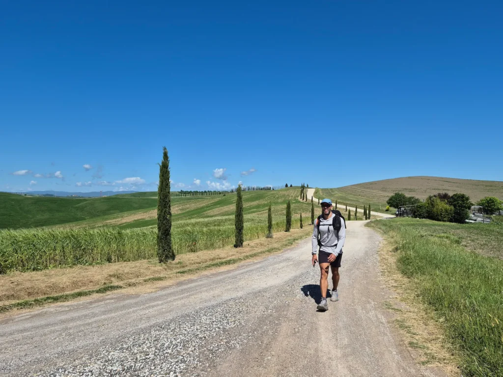Simon walking along a gravel track in Tuscany