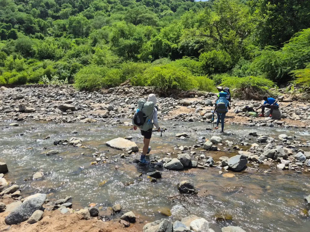 Hikers crossing a river