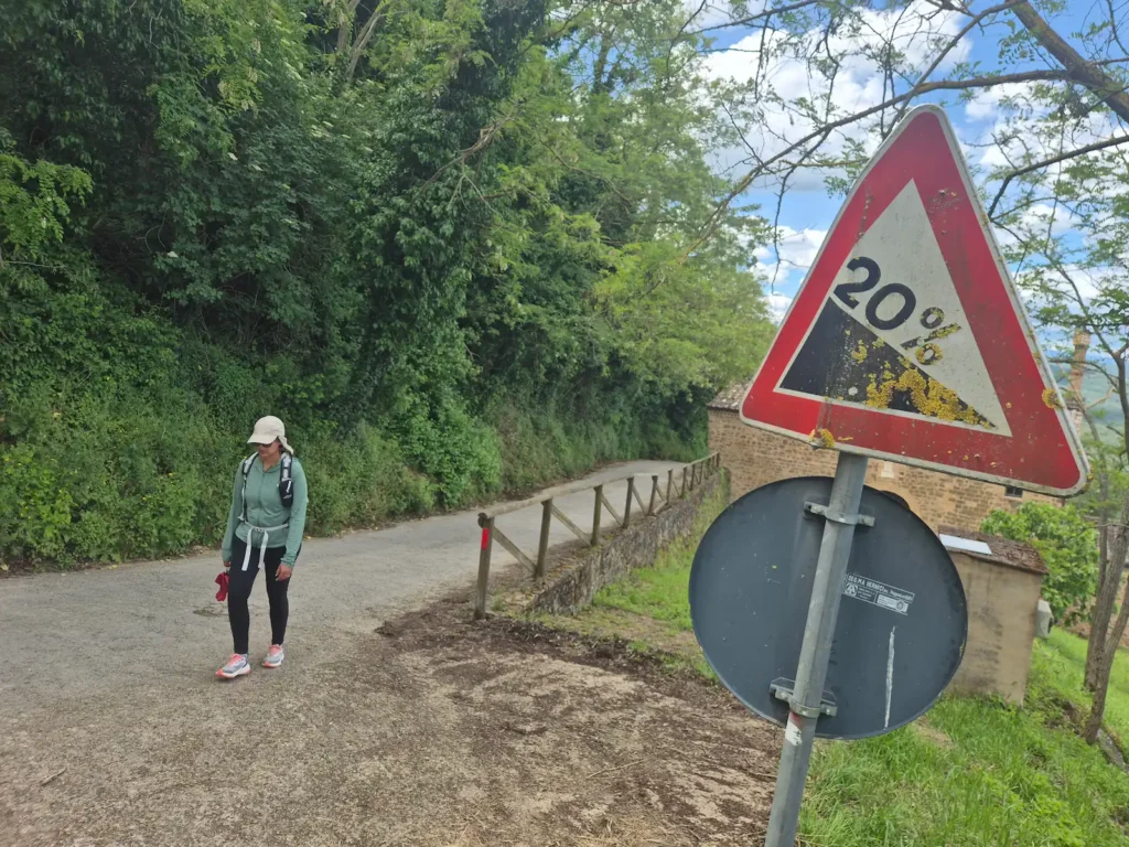 Eve walking up a road with a 20% gradient sign on the side