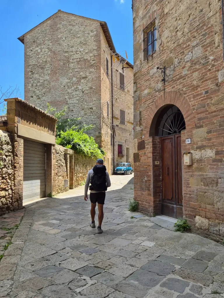Simon walking along a stone street in Montepulciano